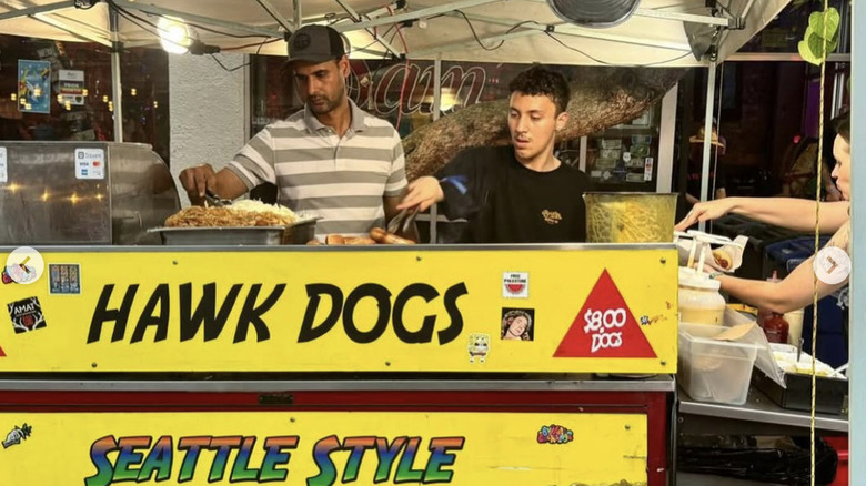 two men serving hot dogs at Hawk Dogs hotdog stand