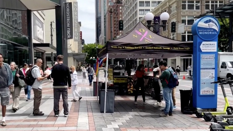 view outside NOLA hot dog stand with people walking around it
