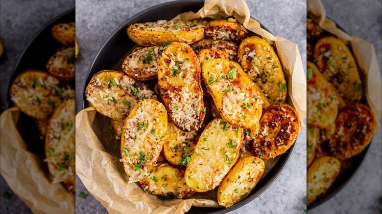 Crispy fingerling potatoes being tossed in fresh herbs and garlic.