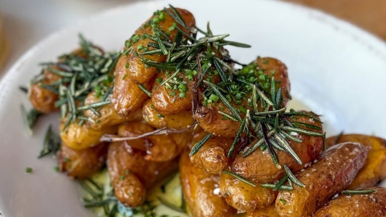 Braised fingerling potatoes with fresh chives and rosemary on top.