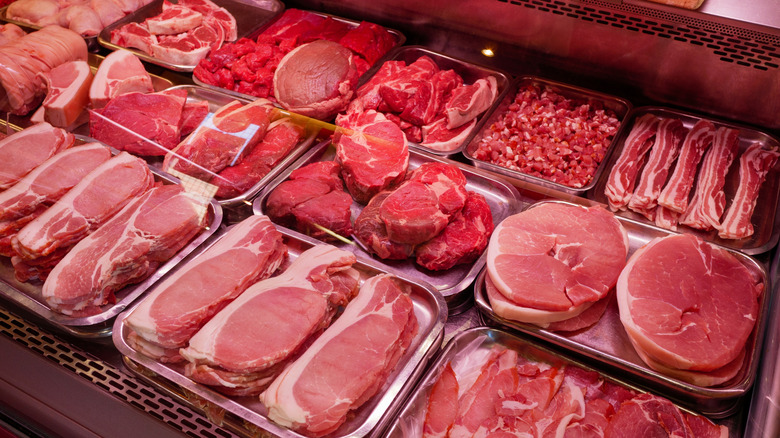 A variety of fresh meats in a butcher shop display