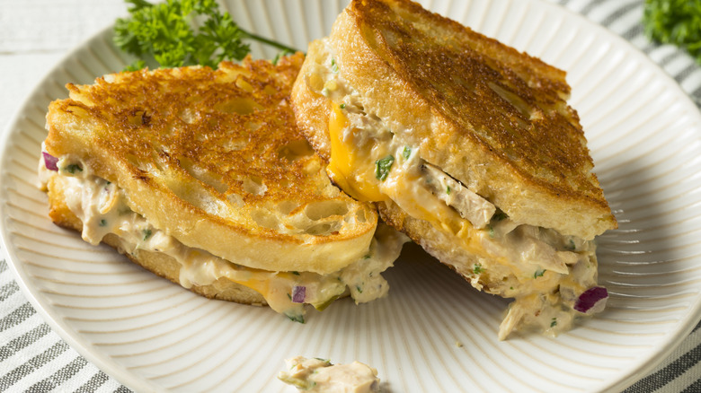 A nicely toasted tuna melt on a white plate