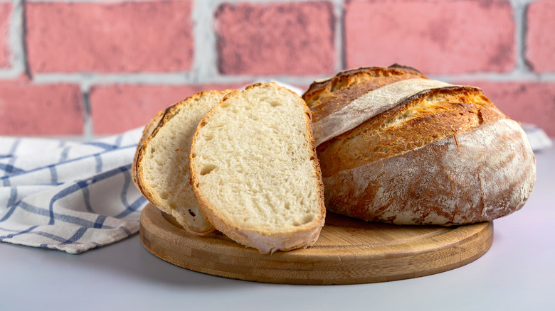 Sliced sourdough and a sourdough loaf on a wooden board
