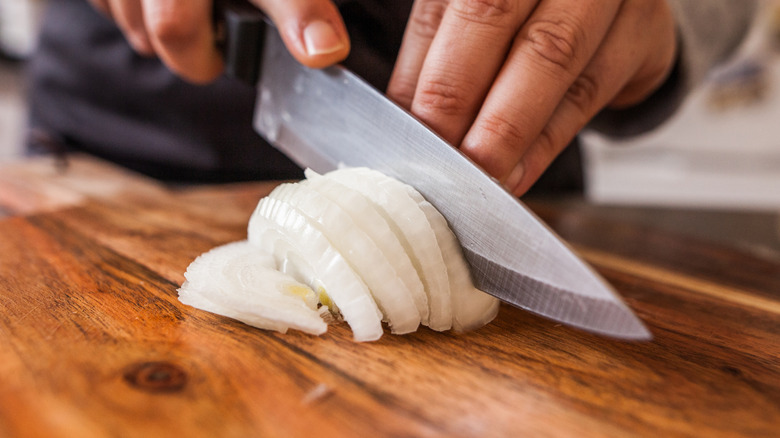 Person chopping white onion