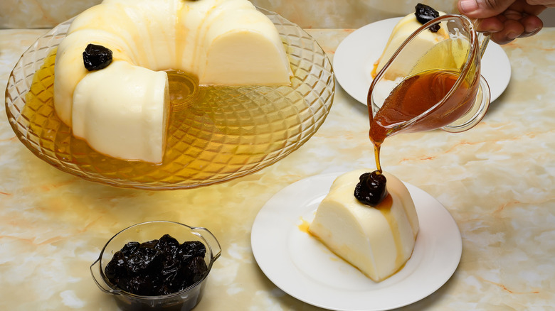 Sweet Biancomangiare presented on a glass serving tray with syrup and candied plums in foreground.