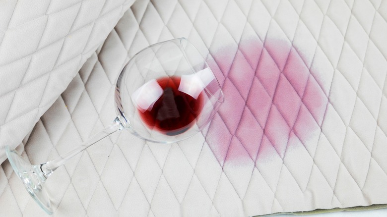 A spilled glass of wine on a white tablecloth.