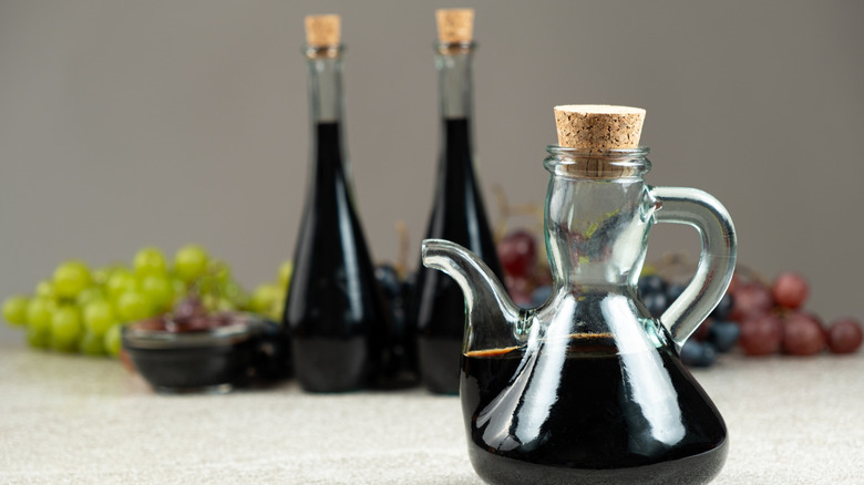 Three unlabeled bottles of balsamic vinegar sealed with a cork.