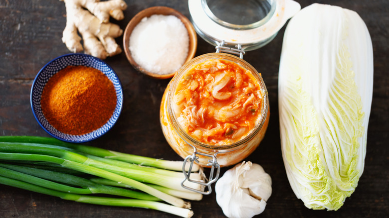 Jar of kimchi surrounded by ingredients
