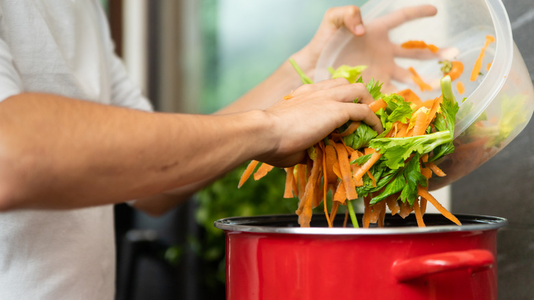Person adds vegetable scraps to stockpot