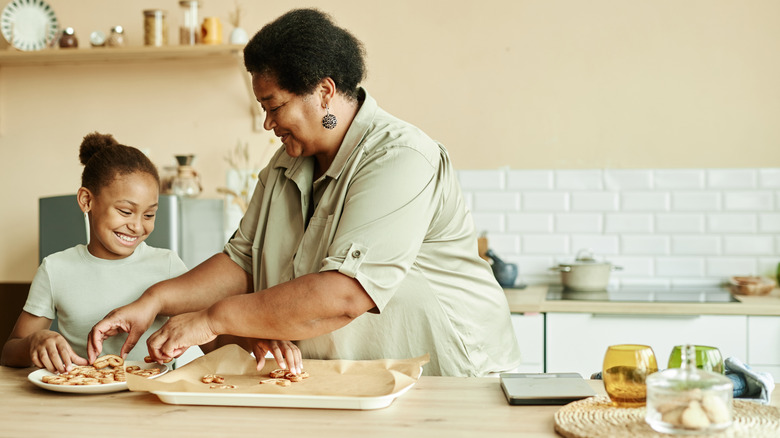 a grandmother and her grandchild baking together in a modern kitchen space