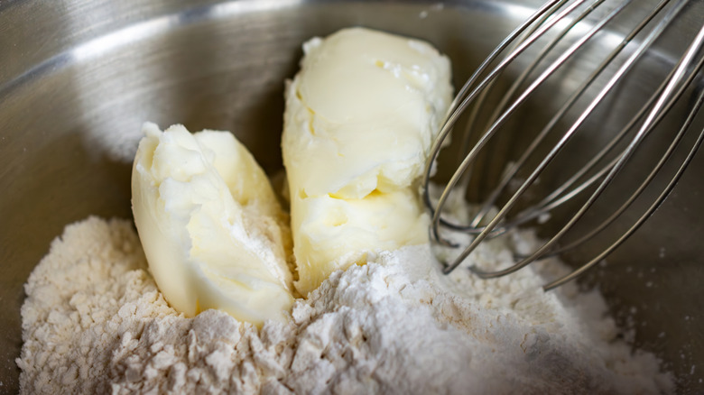 solid shortening in a mixing bowl with flour and a whisk