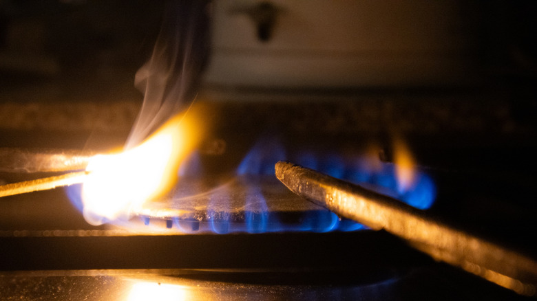 Person igniting a match in a dark kitchen