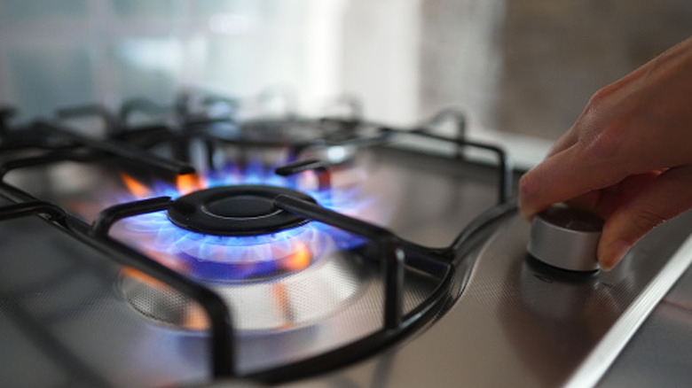 Person turning on a gas stove
