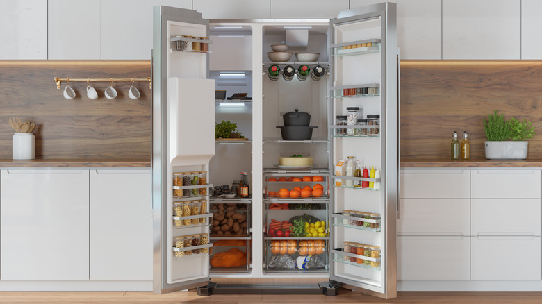 A two-door fridge fully open, revealing its contents