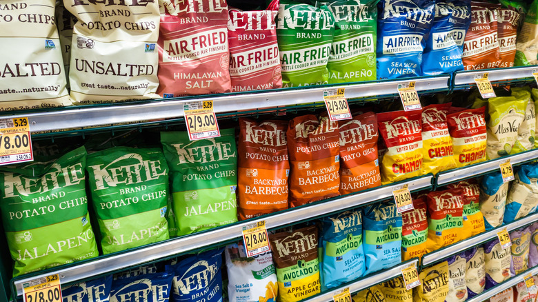 rows of Kettle Brand potato chips on shelves in a grocery store