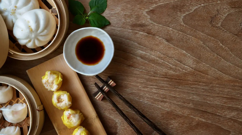 A photo of various dim sum dishes from Dynasty Dumpling with chopsticks and soy sauce in a dipping dish