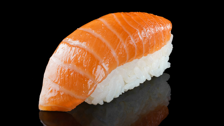 salmon nigiri on black background
