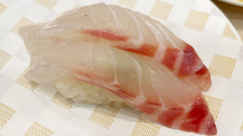 two pieces of red sea bream sushi on a plate