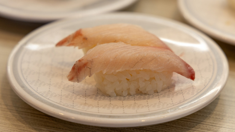 white plate with two pieces of yellowtail nigiri