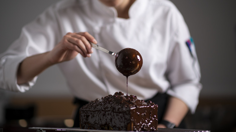 pastry chef pouring chocolate over a loaf cake