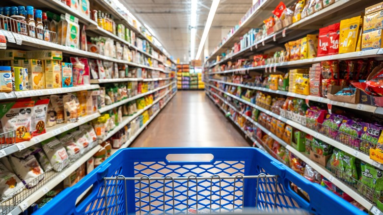 The end of a blue cart in the center of an aisle at Walmart
