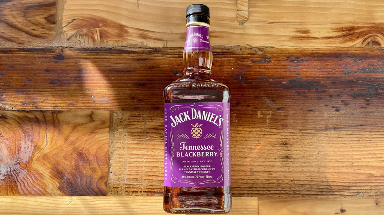 Bottle of Jack Daniel's Tennessee Blackberry lying on wooden tabletop