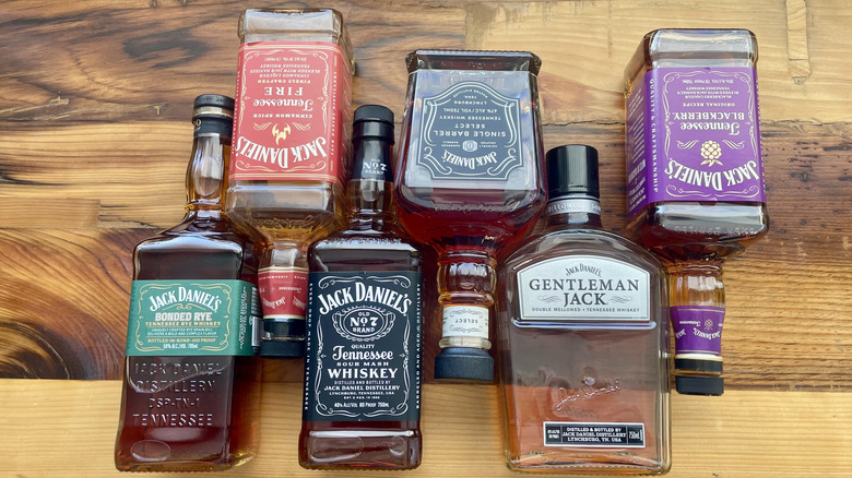 Various Jack Daniel's bottles lying in different directions on a wooden tabletop