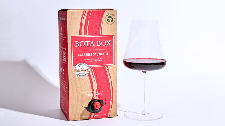 bota box on a table with a glass