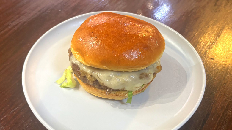 Wahlburgers Impossible burger on a white plate on a wooden table