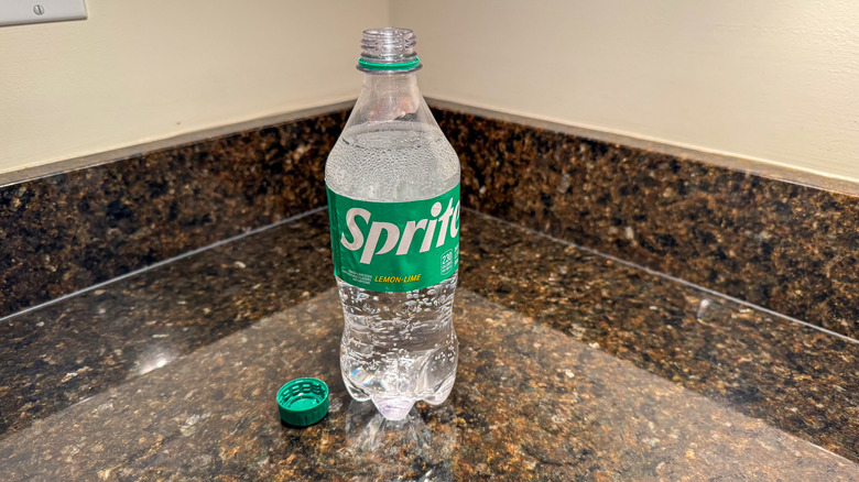 A bottle of Sprite on a counter with the lid removed