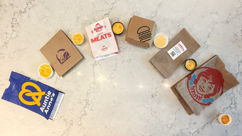 A lineup of chain restaurant cheese sauces and their packages