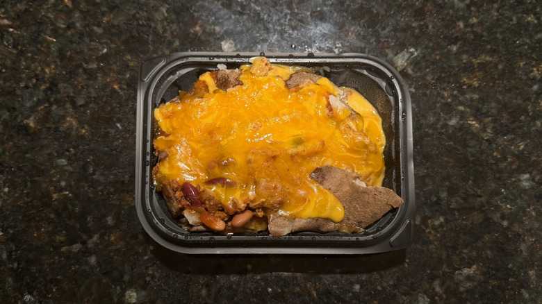Takeout container with Wendy's loaded baked potato on black table