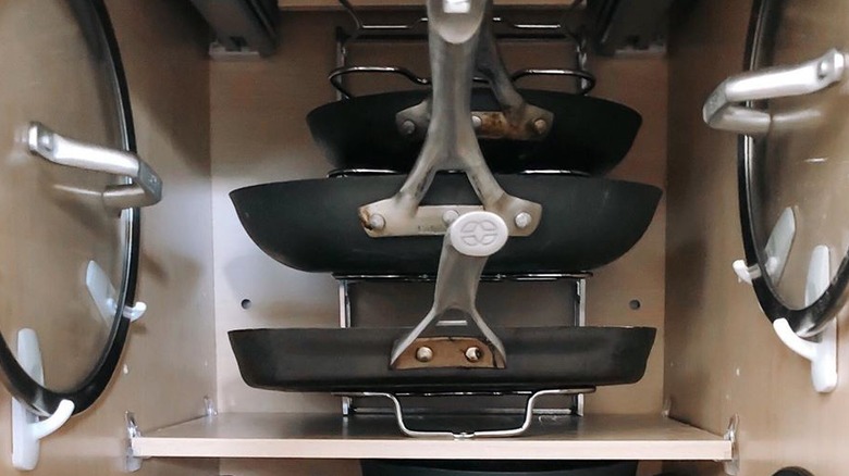 Inside of cabinet with command hooks holding pan lids