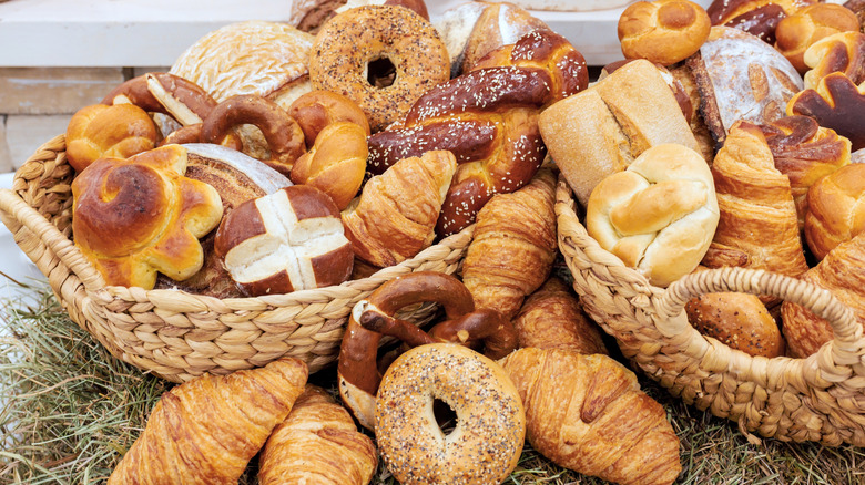 Baskets overflowing with a variety of baked goods like bagels and croissants.