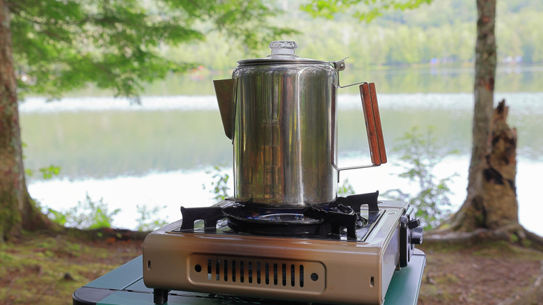 A coffee percolator on a lakeside