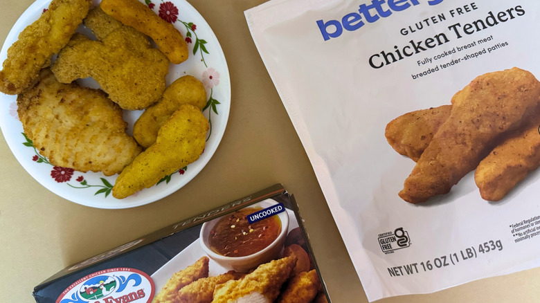 A close-up of plated chicken tenders besides two packages.