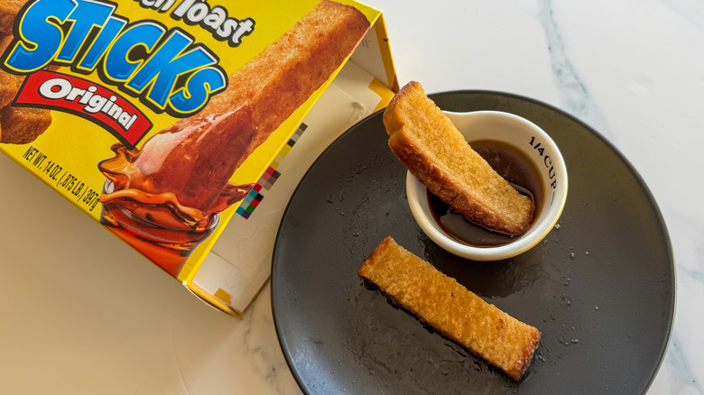 French toast sticks on plate with packaging and syrup