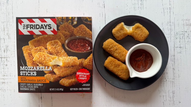 TGI Fridays mozzarella sticks on plate with sauce next to package on table