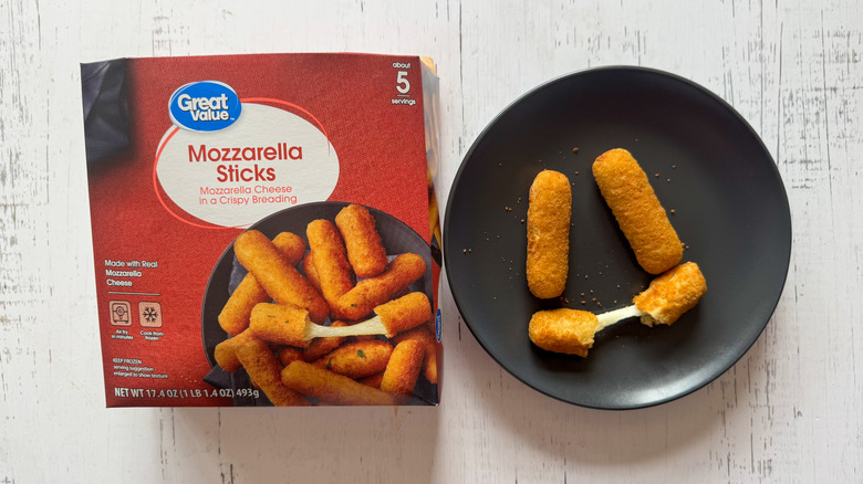 Great Value mozzarella sticks on black plate next to package