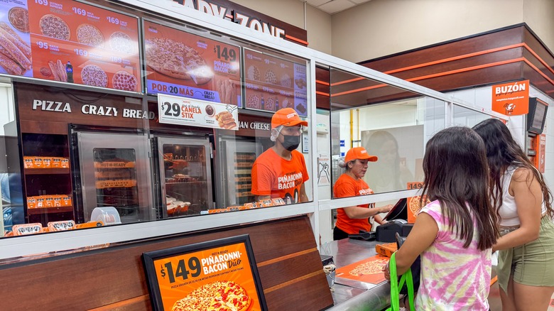 Two customers placing an order at a Little Caesars counter