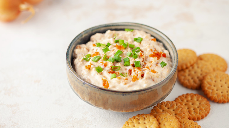 A bowl of French onion dip with crackers