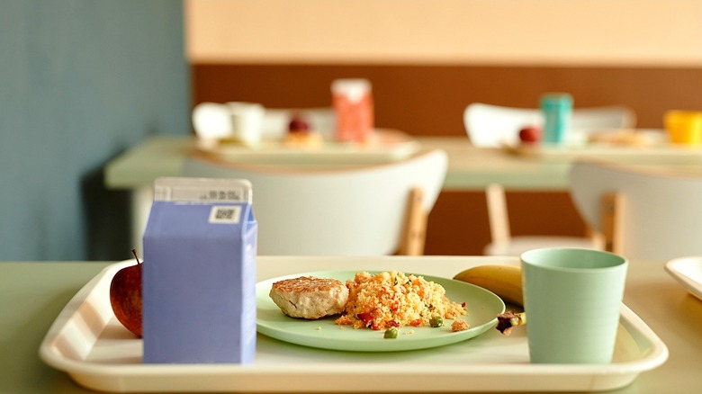 School cafeteria tray with a plate of food, cup, and single-serve milk carton