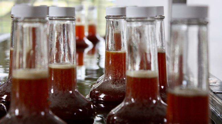 View of the tops of glass bottles full of cane syrup