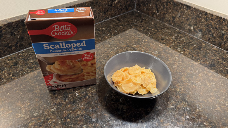 Box of scalloped potatoes with bowl on countertop