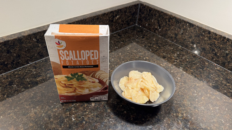 Box of scalloped potatoes with bowl on countertop