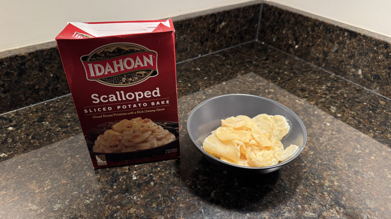 Box of scalloped potatoes with bowl on countertop