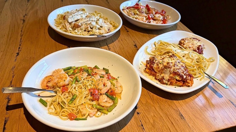 A table with four different Olive Garden entrees