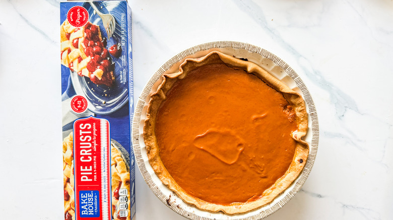 Bake House Creations pie crust packaging beside pumpkin pie