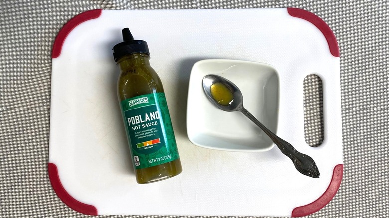 Avoid: Burman's Poblano Hot Sauce on a table with a sample in a spoon