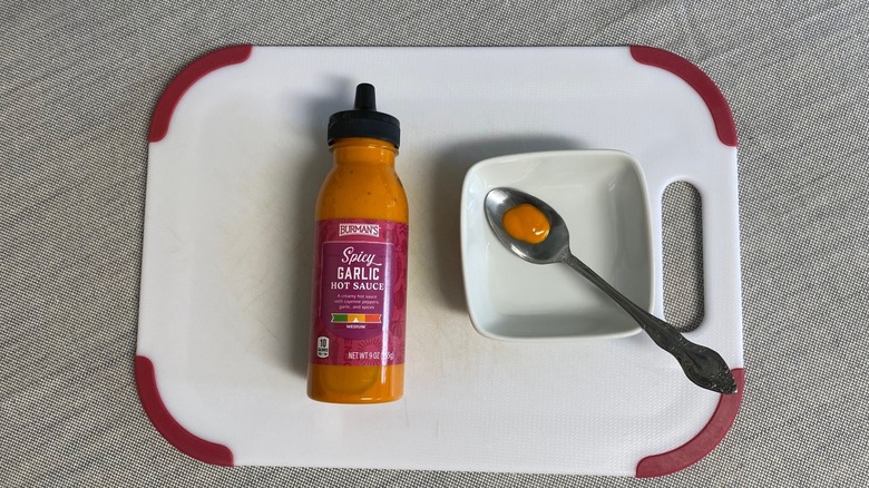 Aldi spicy garlic hot sauce displayed with a sample in a spoon